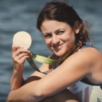 Zoe De Toledo holding her Olympic silver medal on the water in Rio