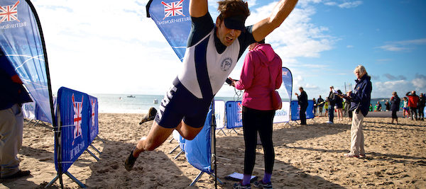 Male rower diving across the finish line on the sand at the British Rowing Offshore Championships