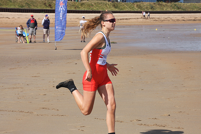 Girl rower sprinting on beach