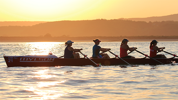 rowing crew in sunset