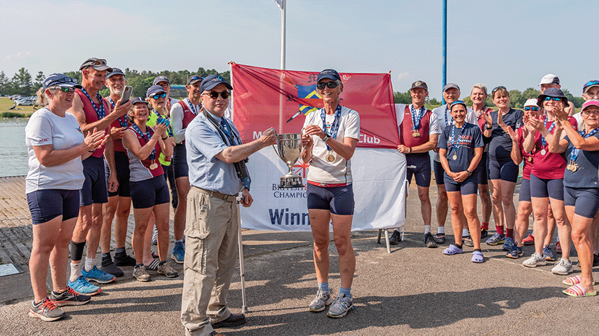 Women being presented with VL trophy by official