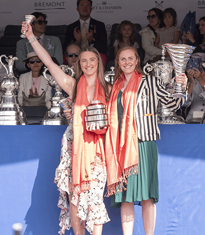 2 women in pink pashminas with silver trophy