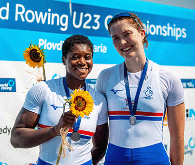 Two women with silver medals and sunflowers