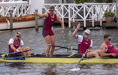 Man standing up in rowing boat celebrating