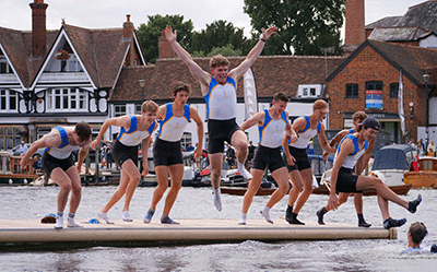 8 boys jumping into river from pontoon