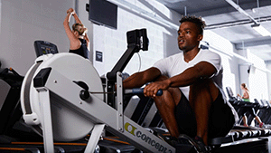 Man on indoor rower in gym