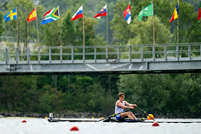 GB junior men's single sculler racing with national flags in background