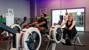 2 people working out on indoor rowers