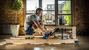 Man on waterrower by window