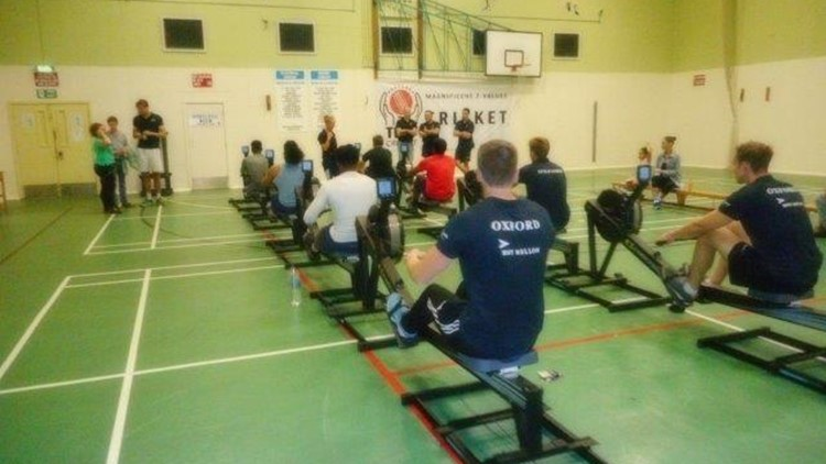 Oxford and Cambridge rowers training in gym with HMYOI Feltham rowers