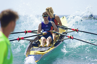 Coastal mixed double setting off from beach through wave