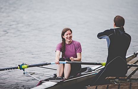 Coach on pontoon with a smiling sculler
