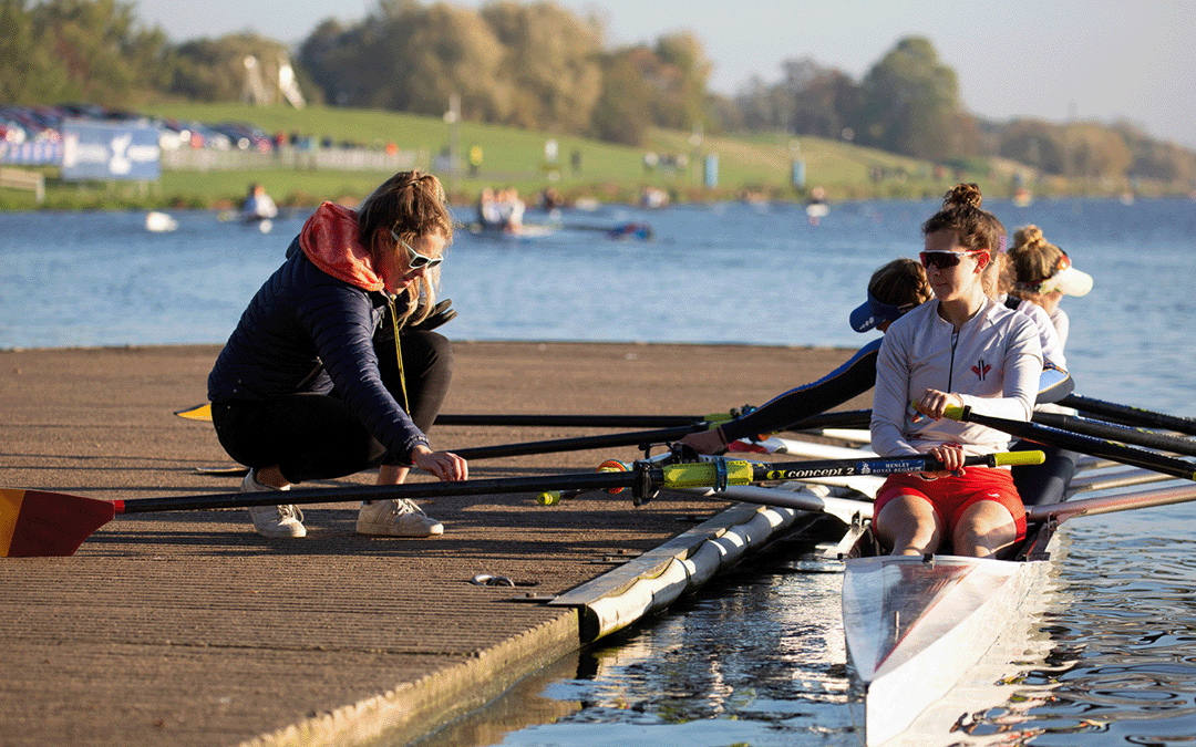 Female athletes on landing stage, rowing in red shorts