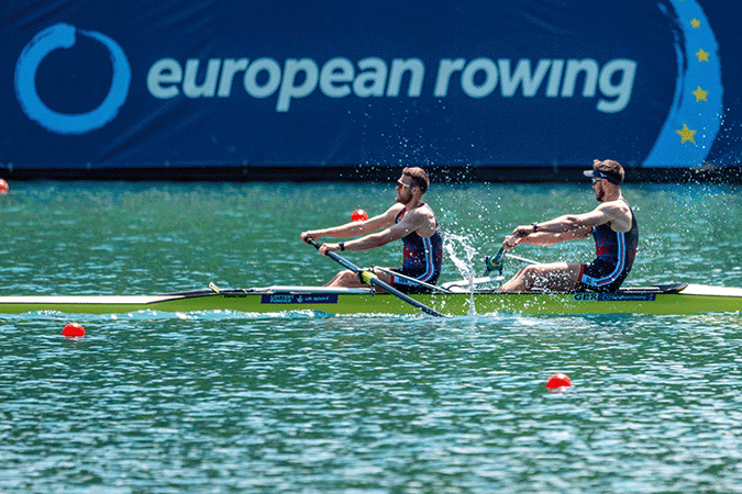 Pair rowing past European Rowing sign
