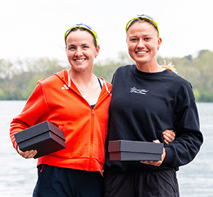 2 female athletes with trophies in boxes