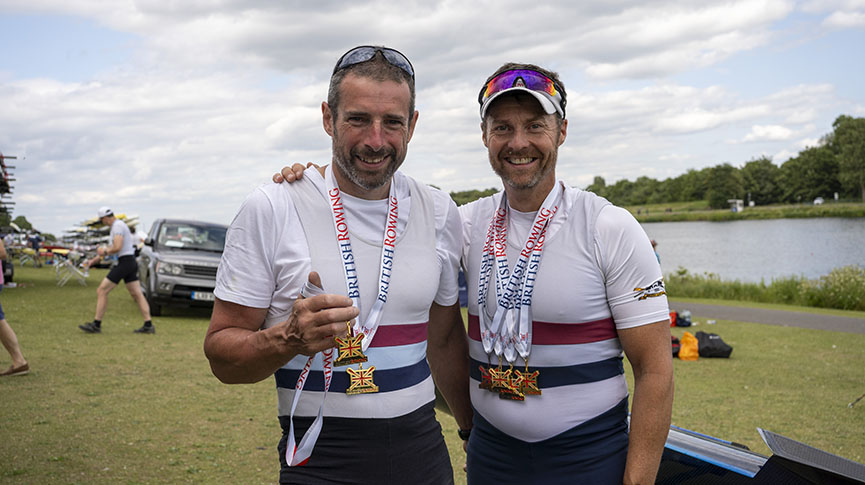 Male rowers pose with medals