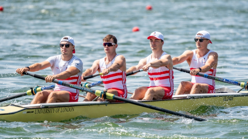 Four rowers in red and white stripes on the water