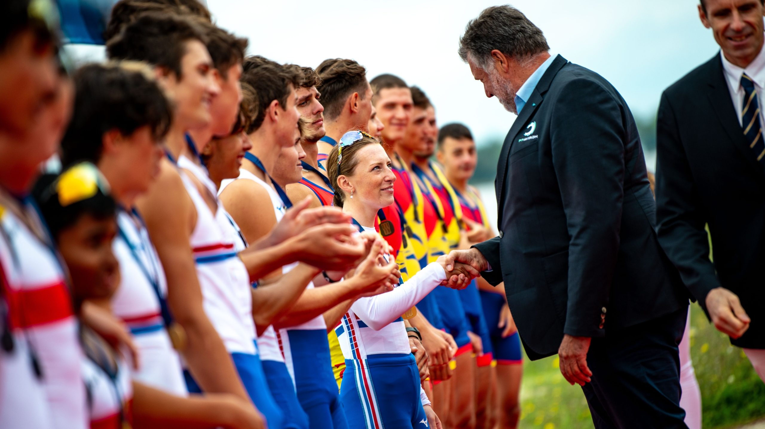 Nat Toms shaking hands on the medal pontoon with an official
